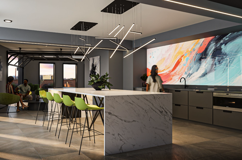 a kitchen with a marble counter and green chairs